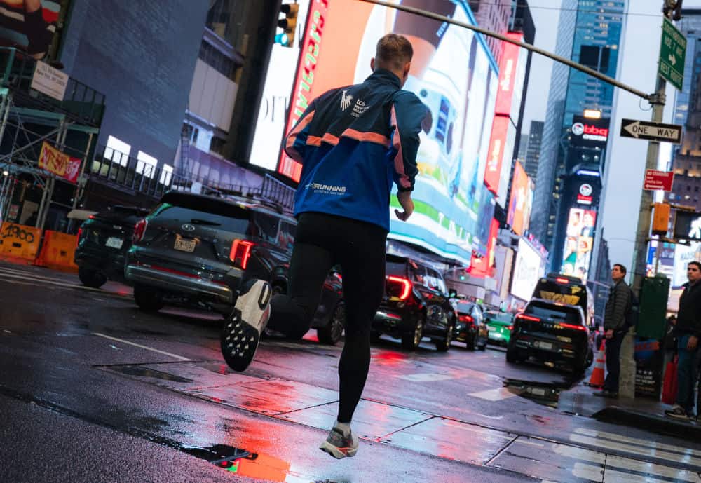 Läufer in blauer Jacke nachts am Times Square